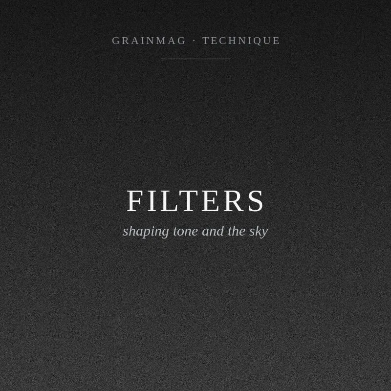 A set of black and white contrast filters arranged beside a panchromatic film box